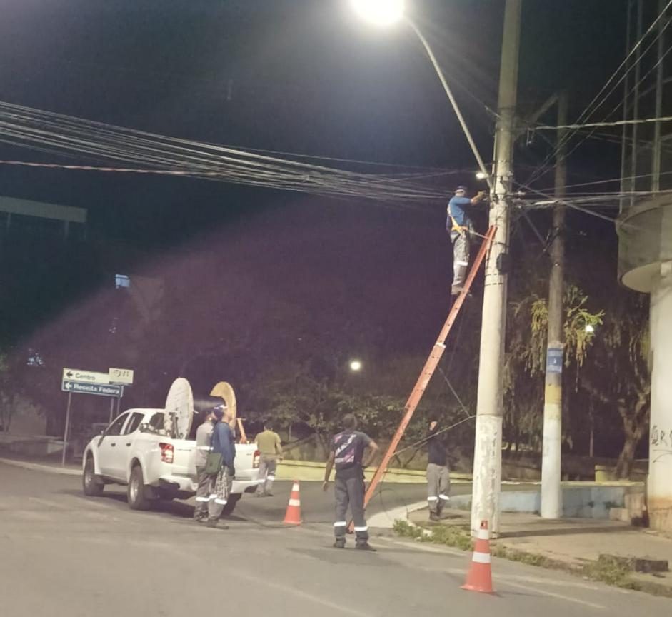 Equipe instala fibra óptica em poste durante a noite em Bom Despacho