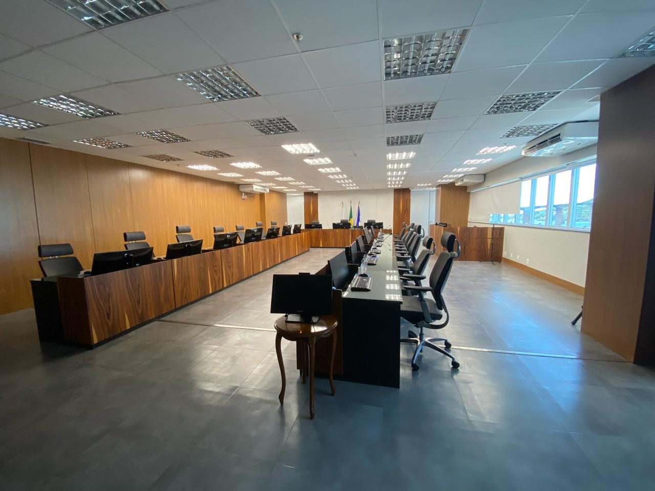 Plenário do TRT da 17ª Região com bancada equipada com microfones de conferência e monitores
