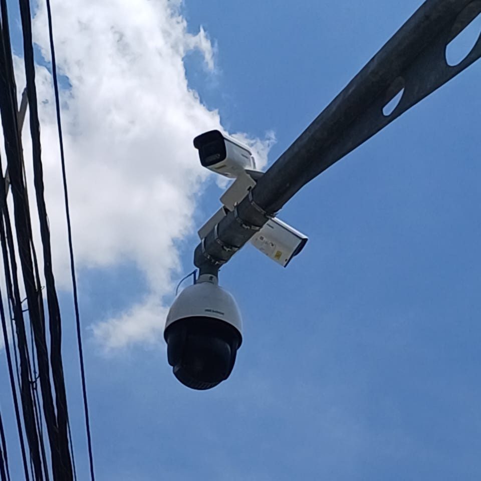 Câmera speed dome e câmeras bullet em braço de poste contra o céu azul de Belo Horizonte (MG)