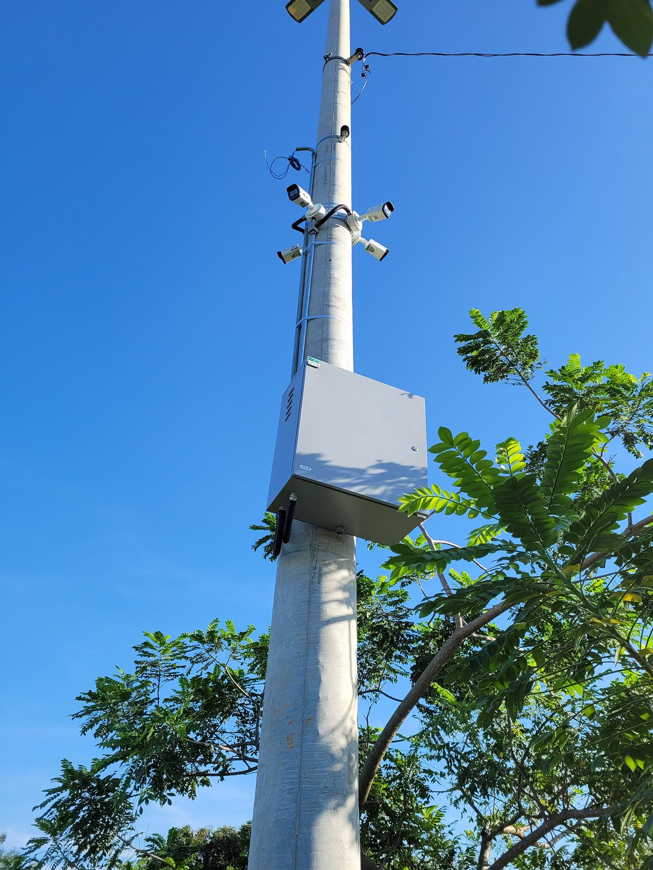 Poste com câmeras de videomonitoramento e caixa de equipamentos sob céu azul em Lucas do Rio Verde (MT)