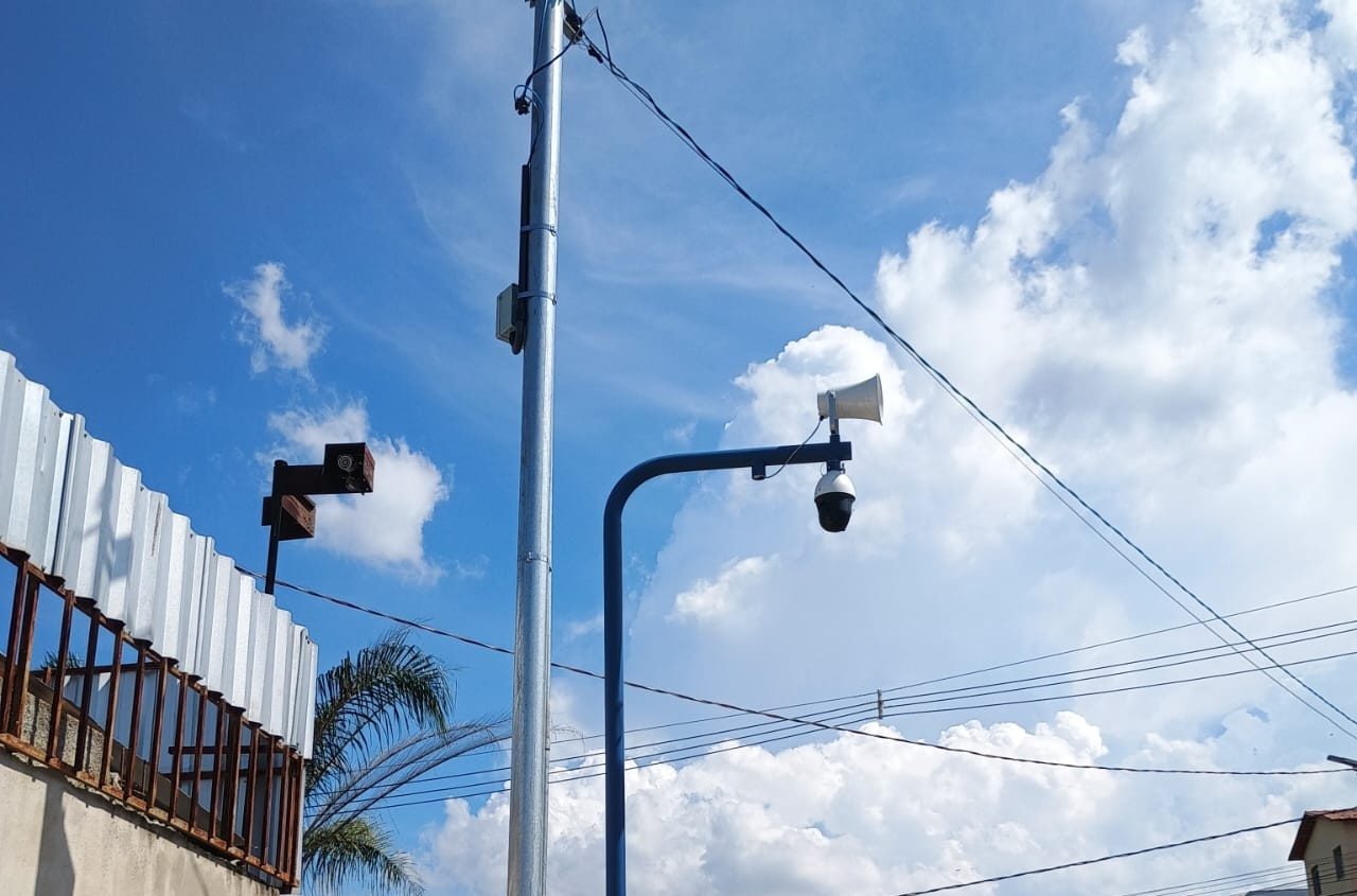 Poste com câmera speed dome e sonofletor sob céu azul em Ribeirão das Neves (MG)