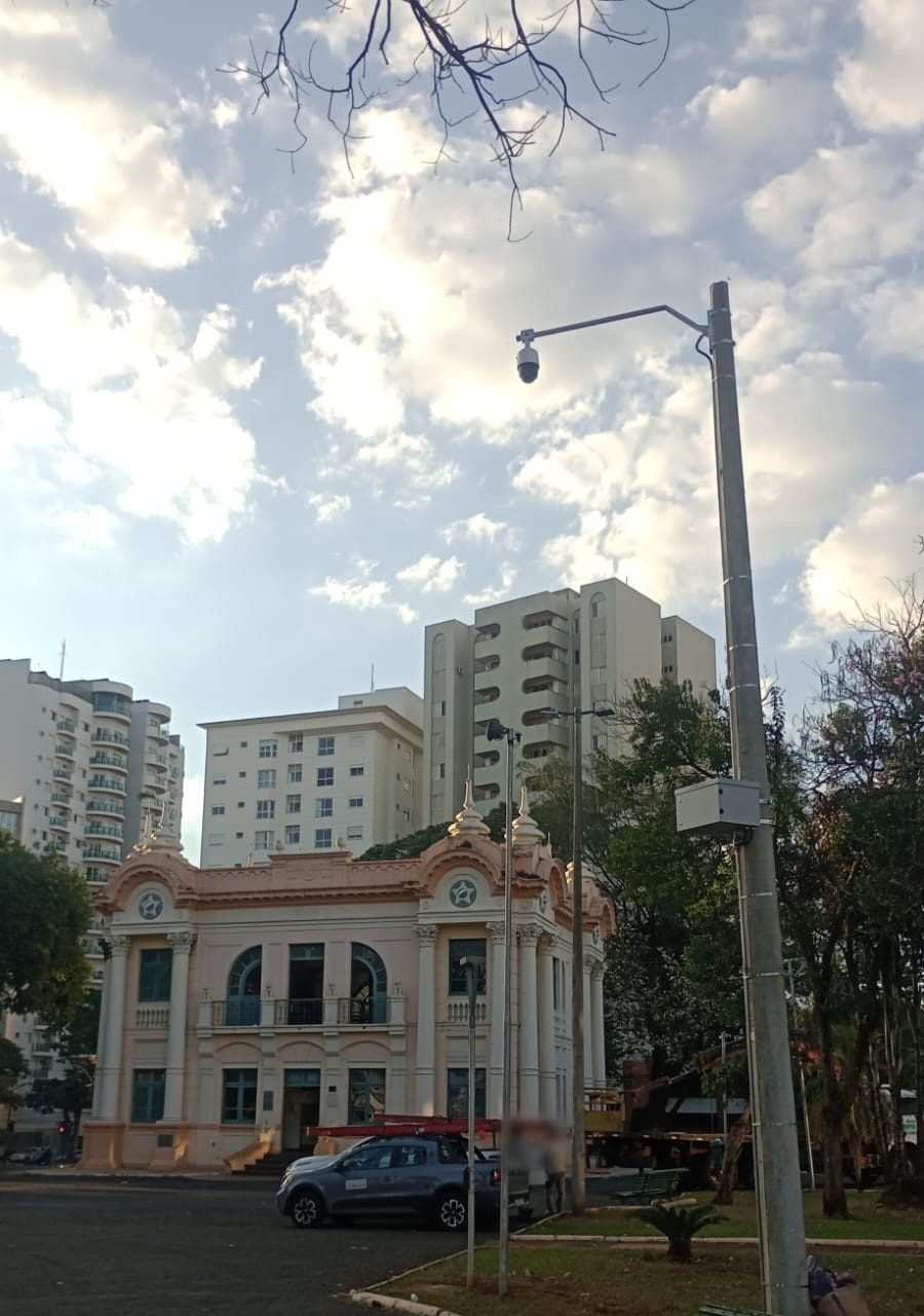 Poste com speed dome e ponto de acesso Wi-Fi em praça de Uberlândia (MG), diante de um prédio histórico